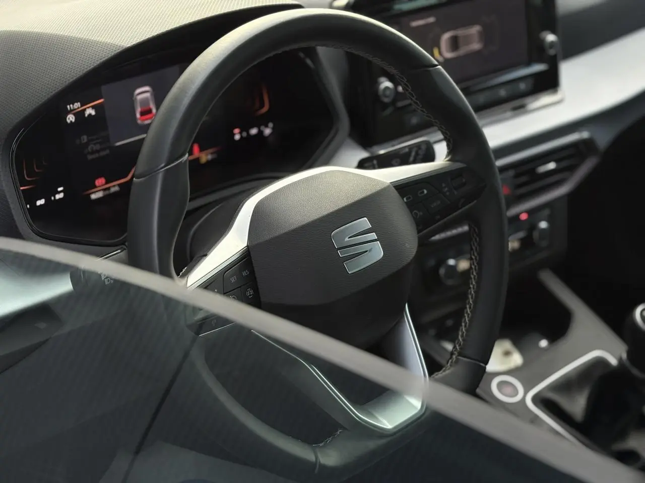 Vue rapprochée du volant noir de la SEAT Ibiza TSI 115 Xcellence 2025 avec tableau de bord digital et commandes intégrées.