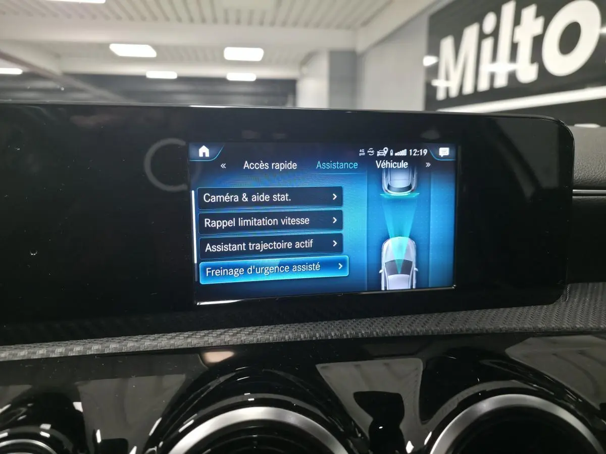 Écran tactile du système multimédia MBUX de la Mercedes Classe A blanc, affichant les aides à la conduite.