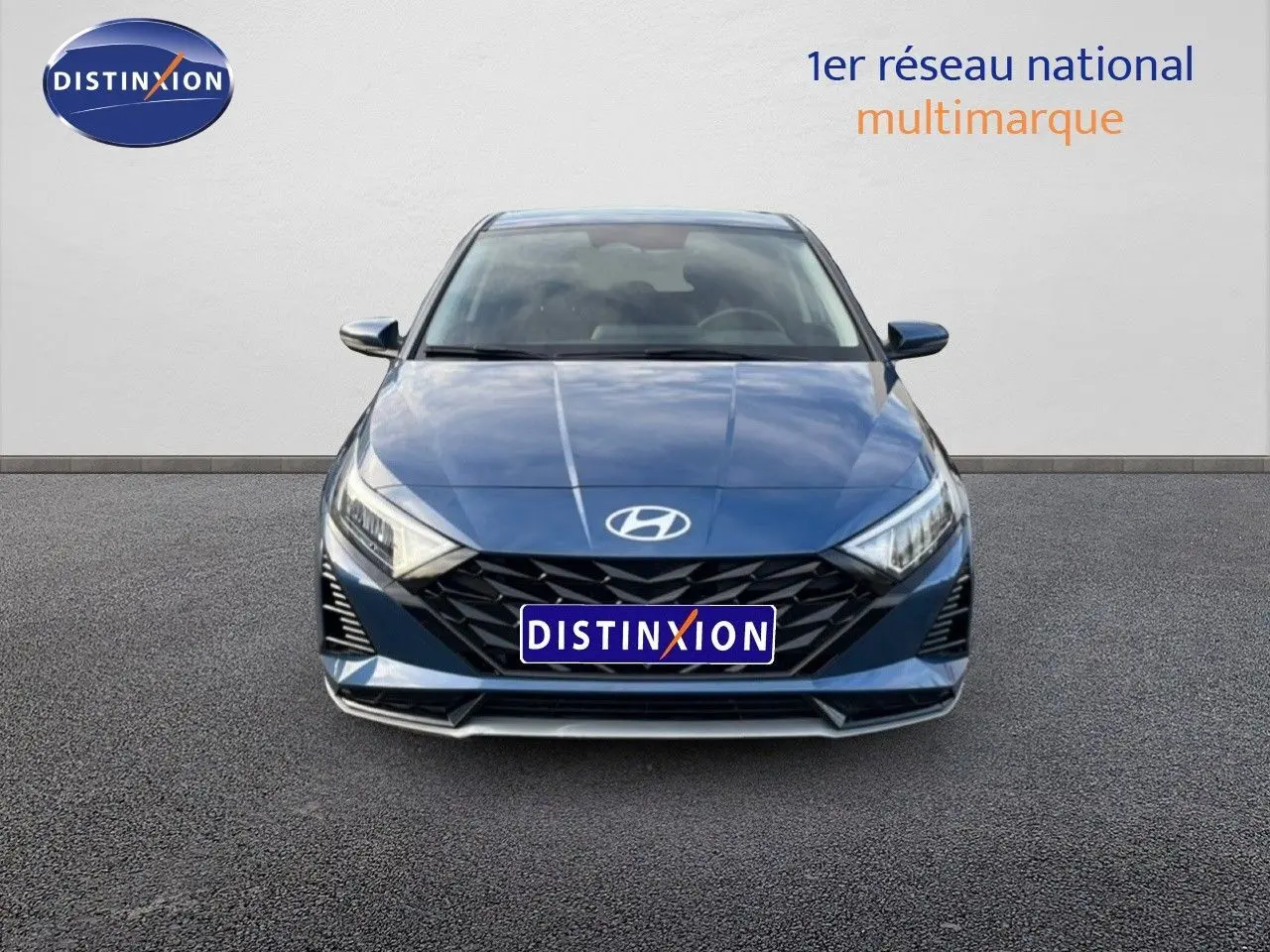 Vue frontale d'une Hyundai i20 1.0 TGDI 100CH KLASS bleu vibrant métal avec calandre noire et phares LED allumés.