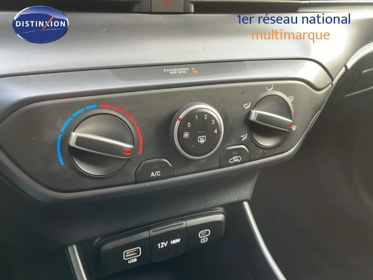 Gros plan sur la commande de climatisation et les ports USB d’une Hyundai i20 2025 en intérieur noir.