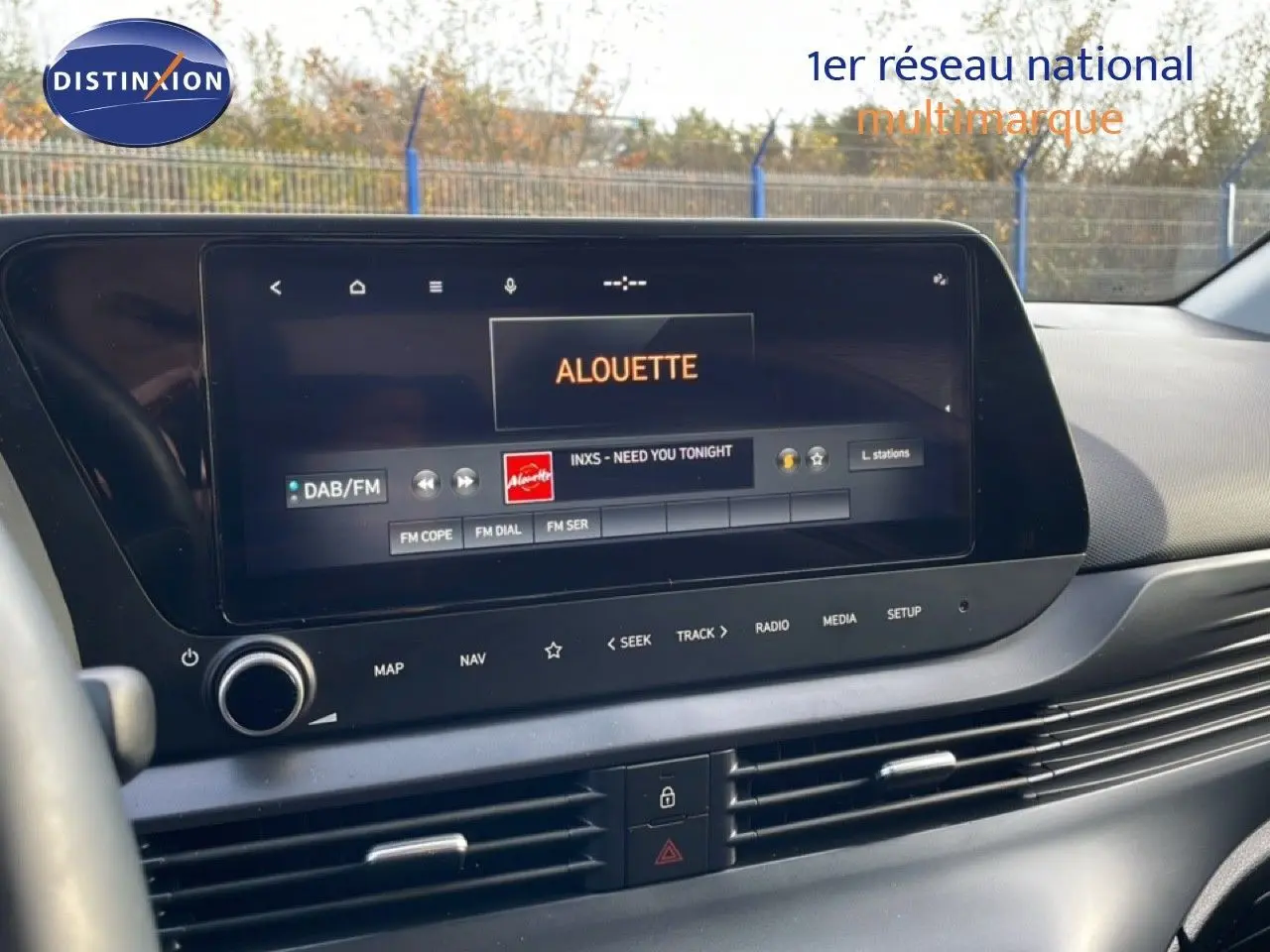 Vue intérieure du tableau de bord de la Hyundai i20 2025 avec écran tactile affichant la radio sur fond noir.