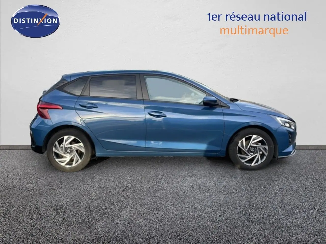 Profil droit de la Hyundai i20 1.0 TGDI 100CH KLASS 2025 en bleu vibrant métallisé, avec jantes alliage et vitres teintées.