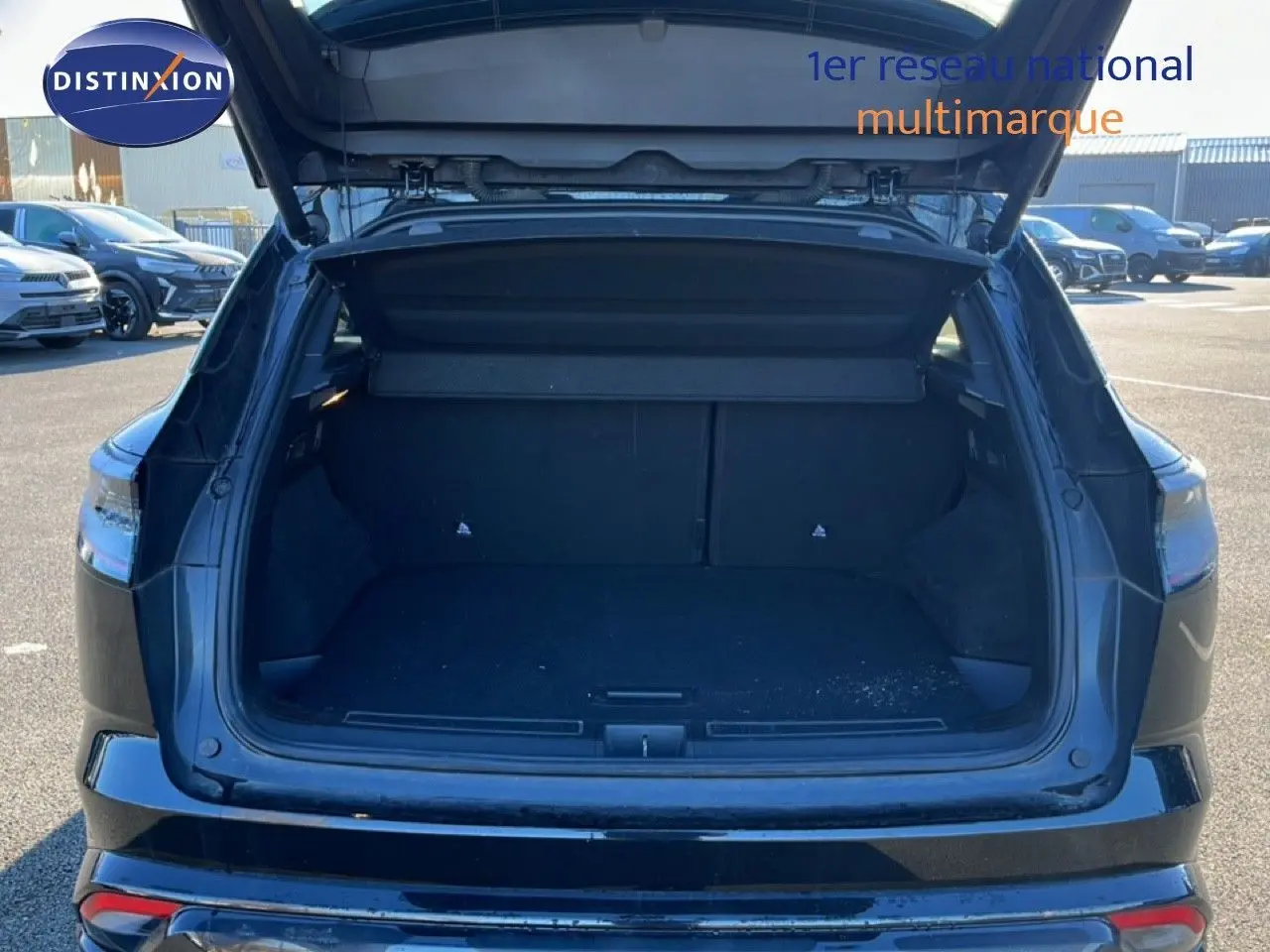 Coffre ouvert vu de l'arrière d'un Renault Austral noir étoile métal 2023, montrant l'espace de chargement vide.