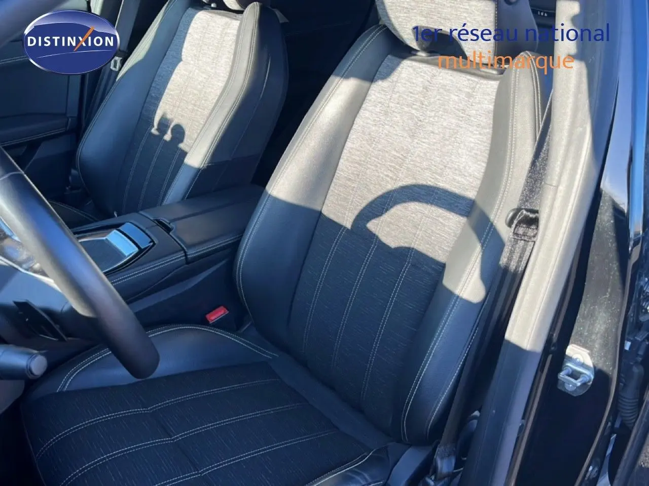 Vue intérieure côté conducteur du Renault Austral 2023 noir étoile métal, siège en tissu et cuir noir avec surpiqûres blanches.