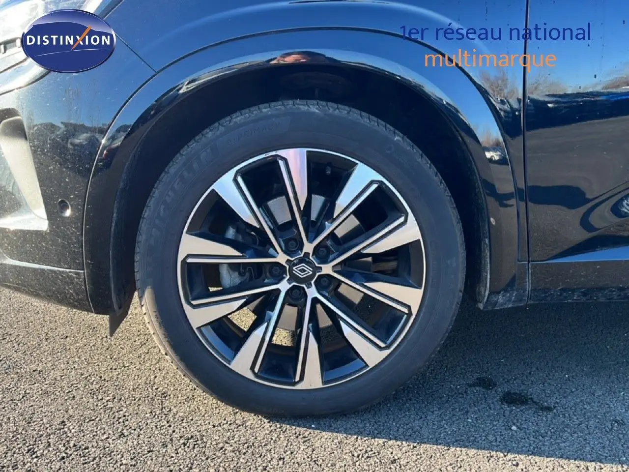 Gros plan sur la roue avant gauche et la jante noire et argent du Renault Austral noir étoile métal.