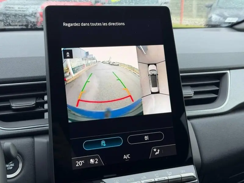 Écran tactile intérieur du Renault Captur 2025 montrant la caméra de recul avec vue arrière et dessus du véhicule bleu Iron/Noir Etoilé.
