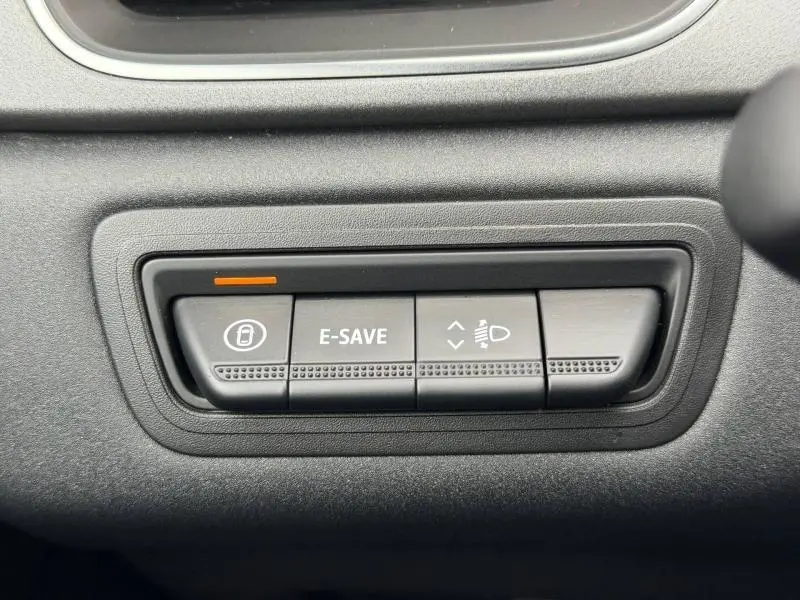 Gros plan sur les boutons de commande E-SAVE et réglage des phares dans l’habitacle du Renault Captur 2025.