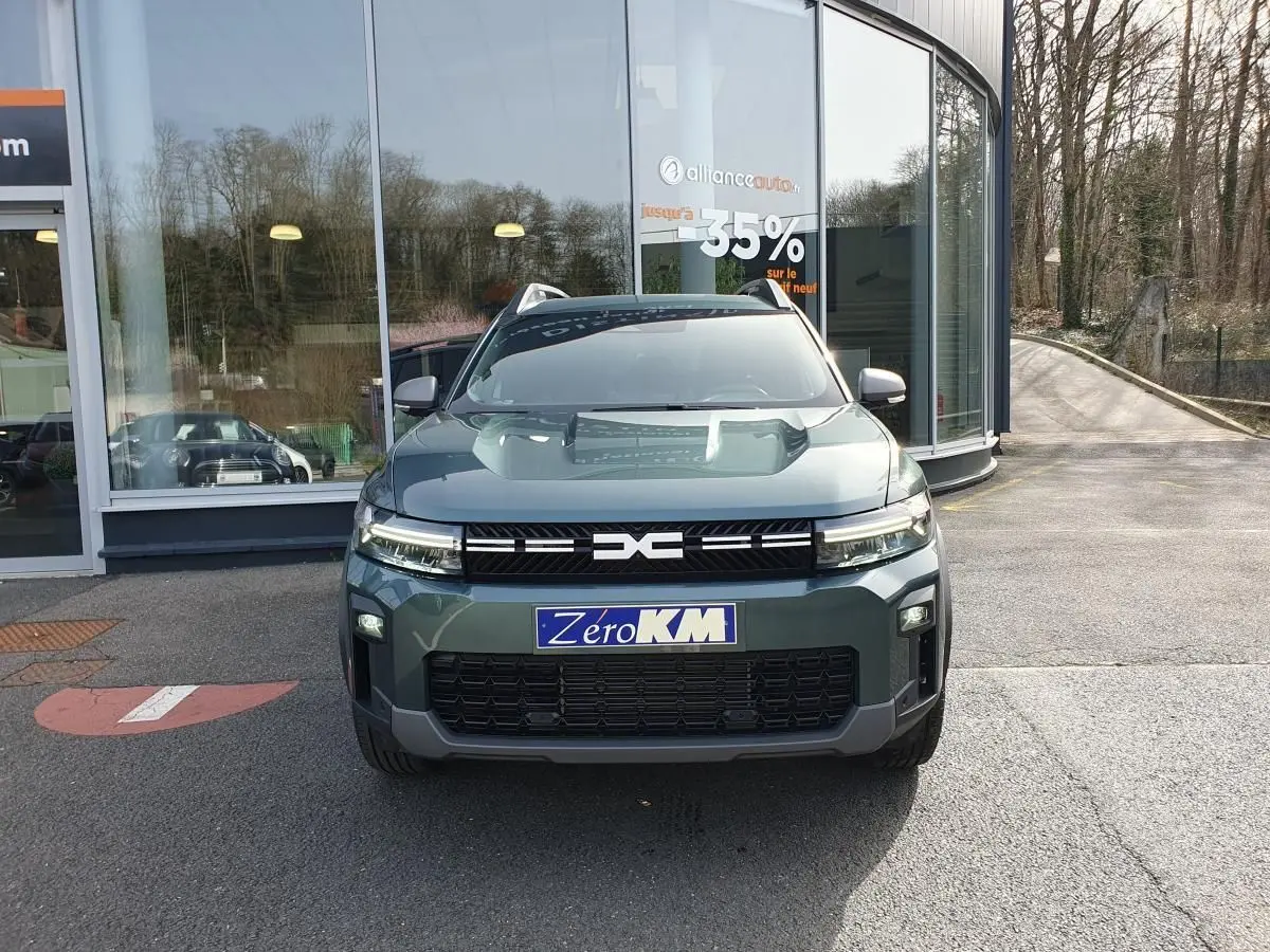 Vue de face du Dacia Bigster vert cèdre avec toit panoramique et signature lumineuse LED visible.