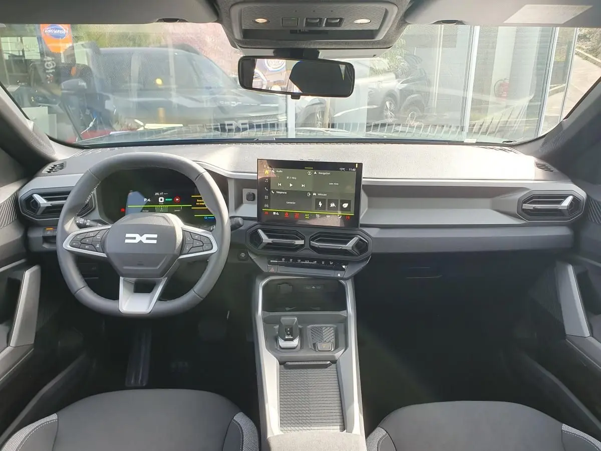 Vue intérieure avant du tableau de bord et volant du Dacia Bigster 2026, avec écran tactile central et design moderne noir.
