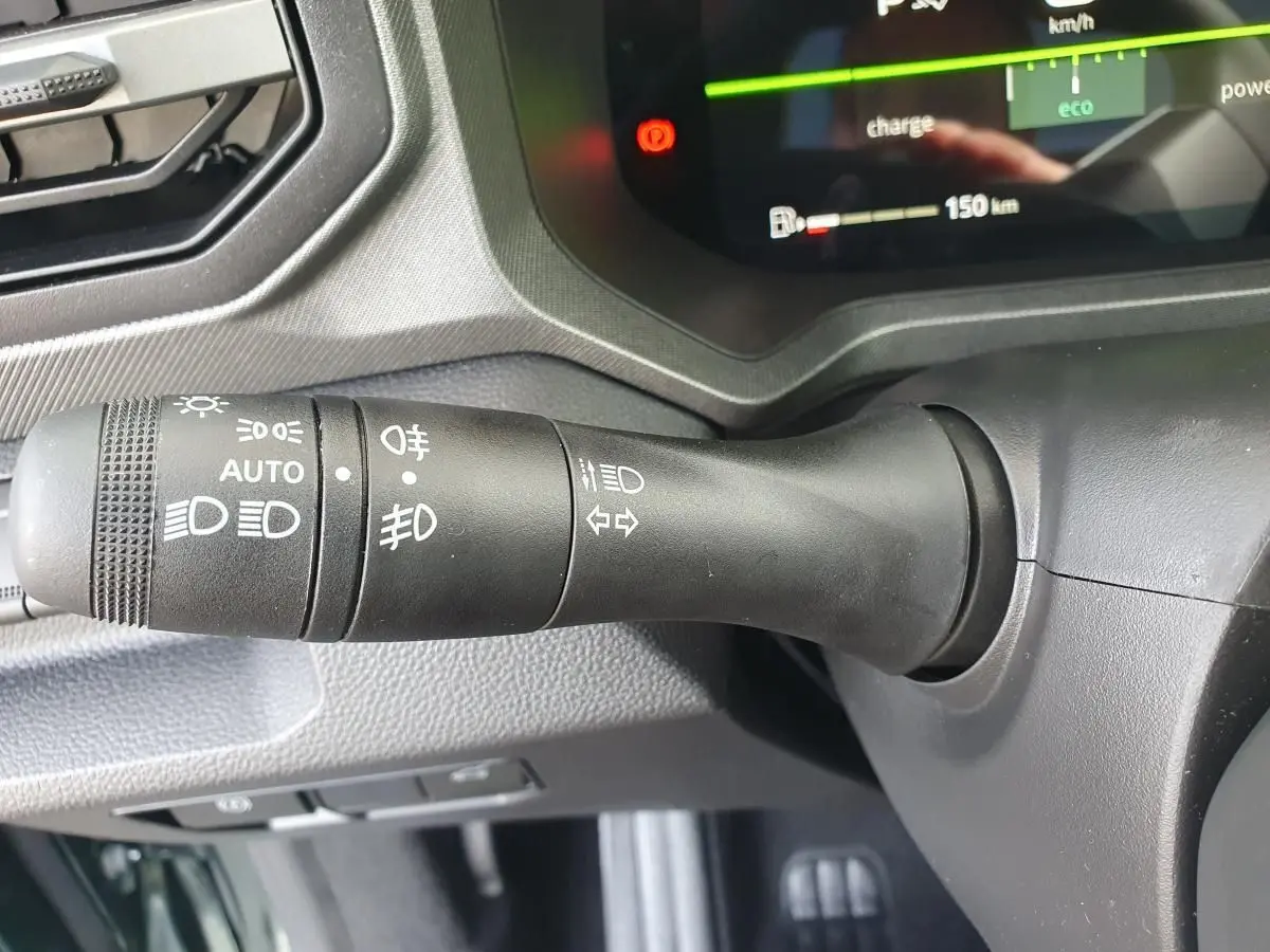 Gros plan sur la manette de commande des feux du tableau de bord du Dacia Bigster, intérieur noir.