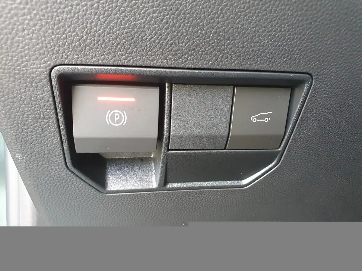 Gros plan sur les boutons de frein de parking électrique et ouverture du coffre du Dacia Bigster, intérieur noir.