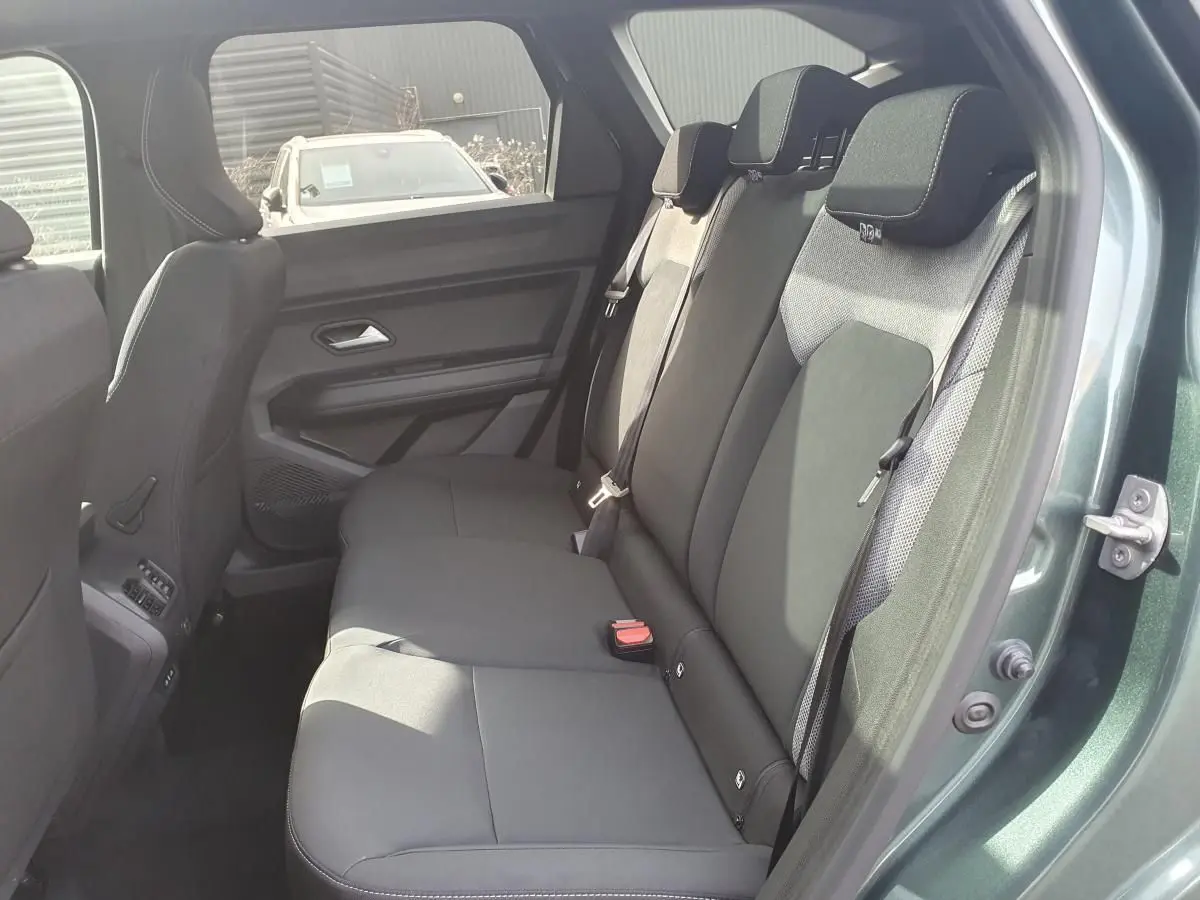 Vue côté droit sur la banquette arrière noire du Dacia Bigster vert cèdre avec ceinture et appuie-têtes visibles.