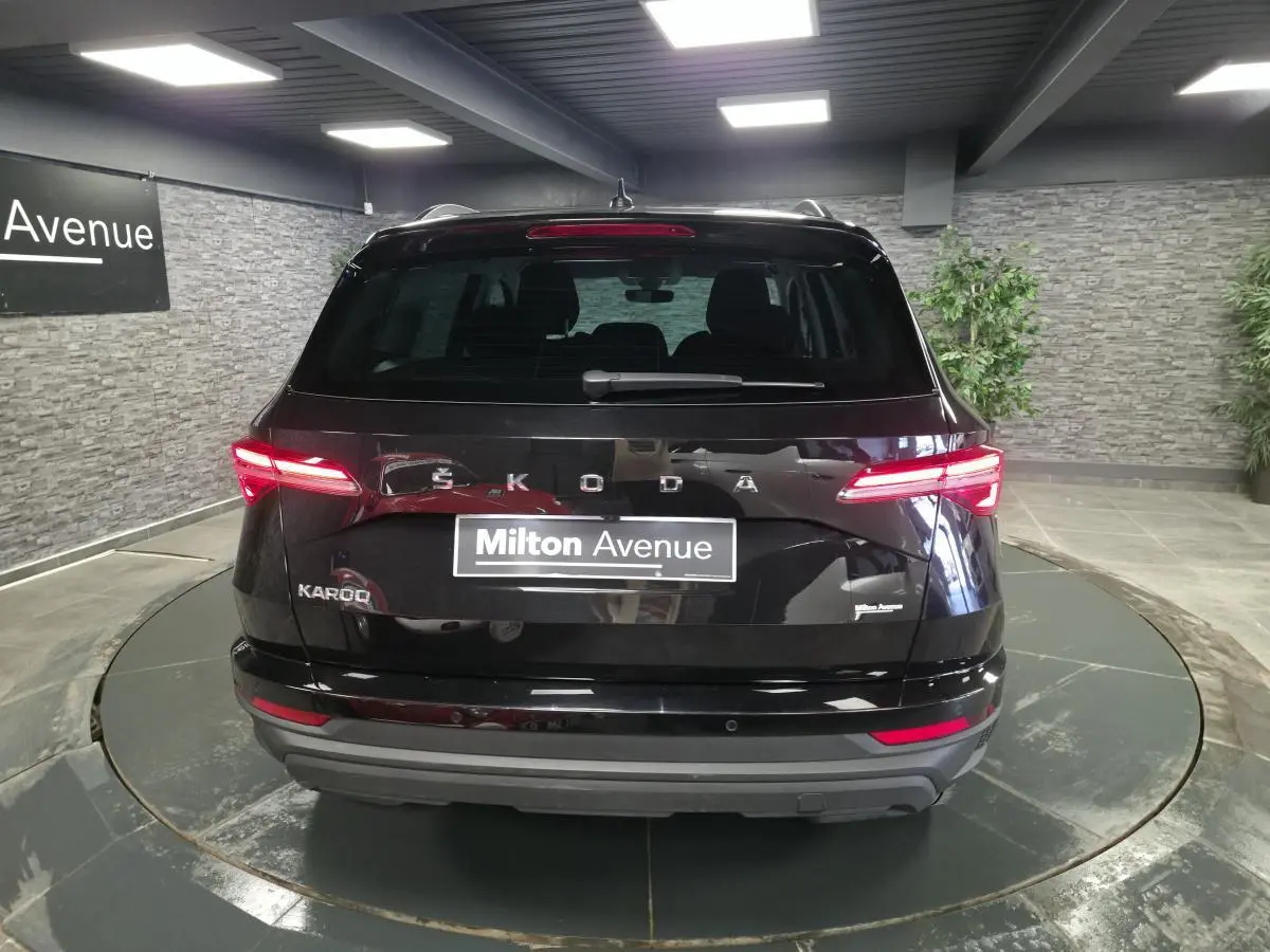 Vue arrière d'un Skoda Karoq noir 2023 avec feux LED allumés dans un showroom intérieur.