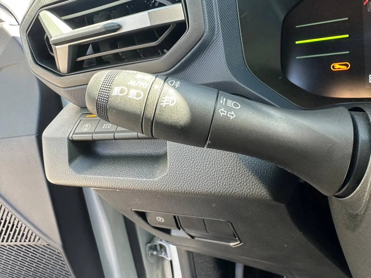 Gros plan sur la commande des feux et clignotants du Dacia Duster 2025 couleur Sandstone, intérieur noir.