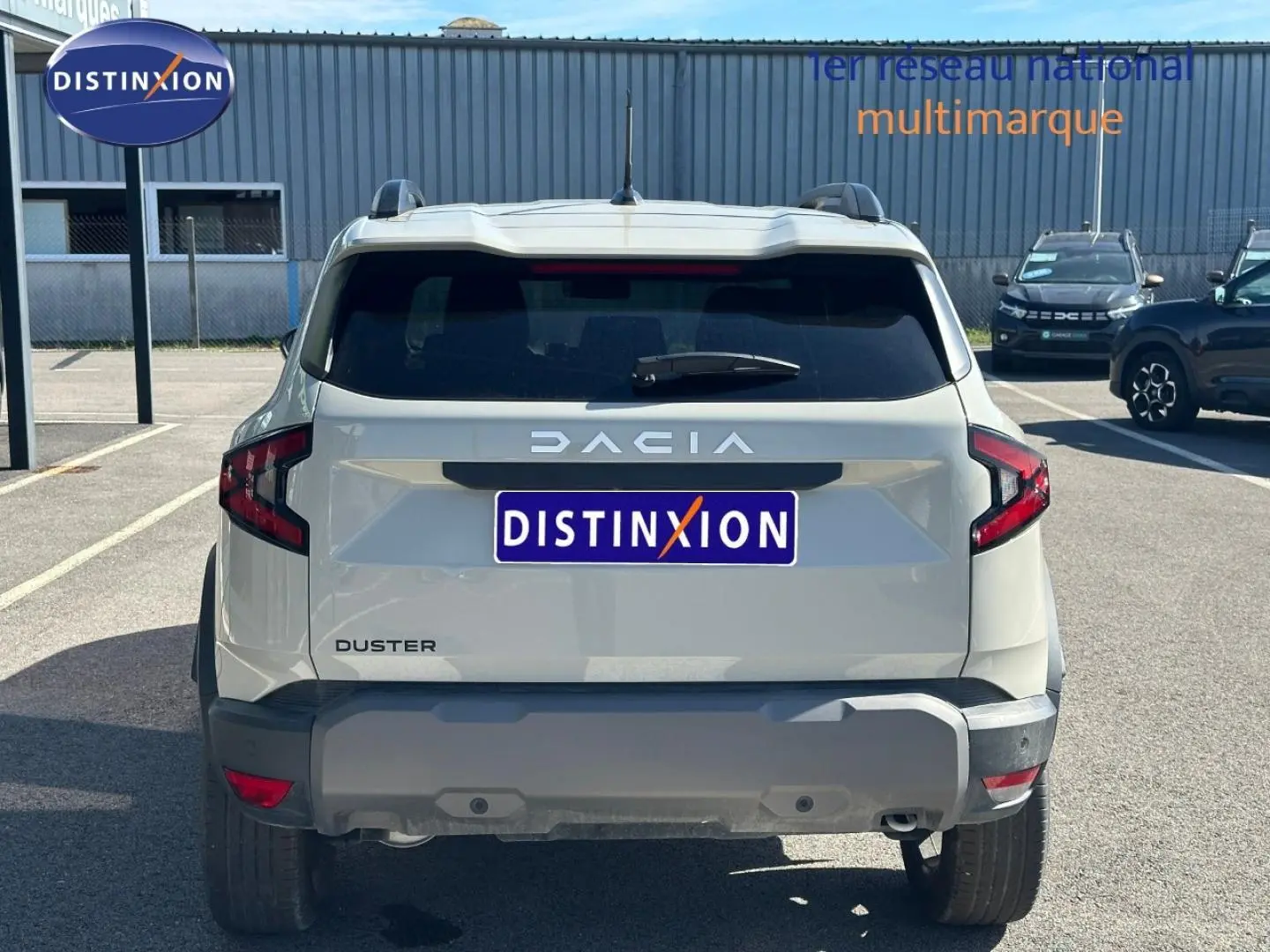 Vue arrière d'un Dacia Duster 2025 couleur Sandstone avec barres de toit et feux arrière LED distinctifs.