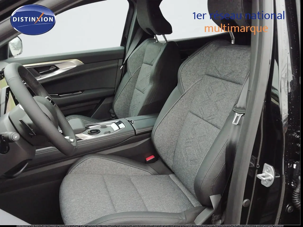Vue intérieure côté conducteur du Renault Austral 2026 noir étoile métal, sièges tissu gris avec surpiqûres et volant multifonction.
