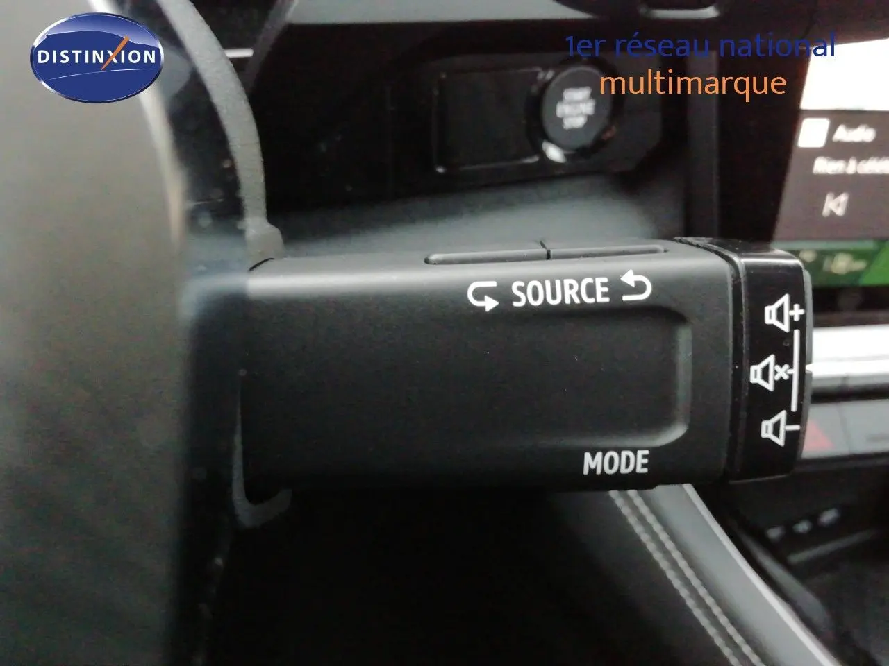 Gros plan sur la commande au volant du Renault Austral noir étoile métal, avec boutons source et mode visibles.