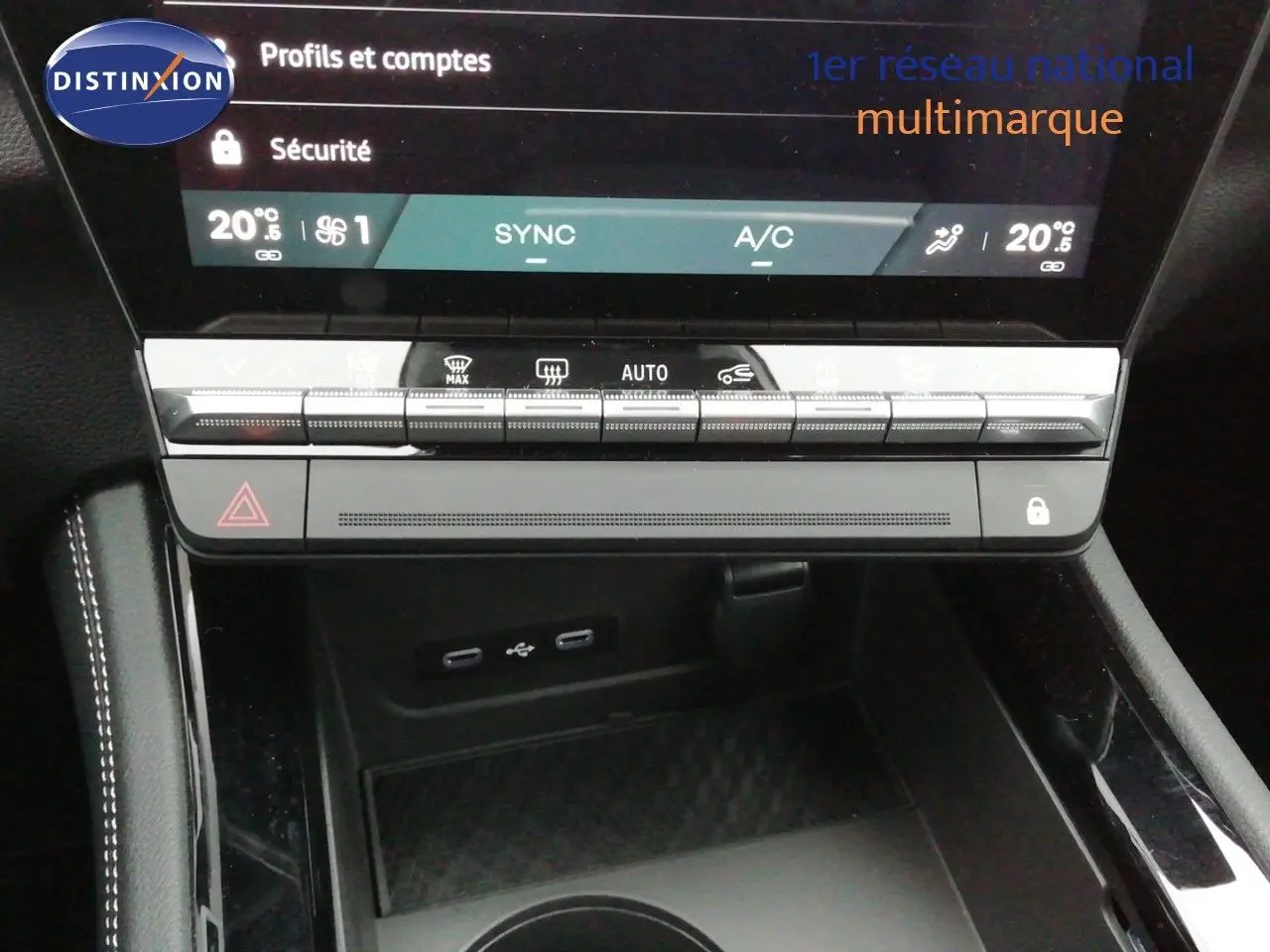 Vue rapprochée du tableau de bord et console centrale du Renault Austral noir étoile métal, avec commandes climatisation et ports USB visibles.