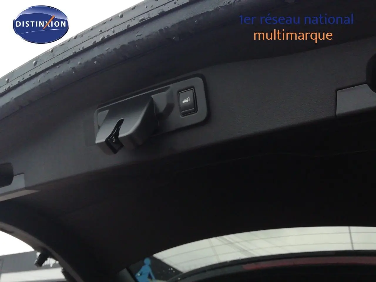 Vue intérieure du hayon ouvert d’un Renault Austral noir étoile métal, montrant la poignée et le bouton d’ouverture électrique.