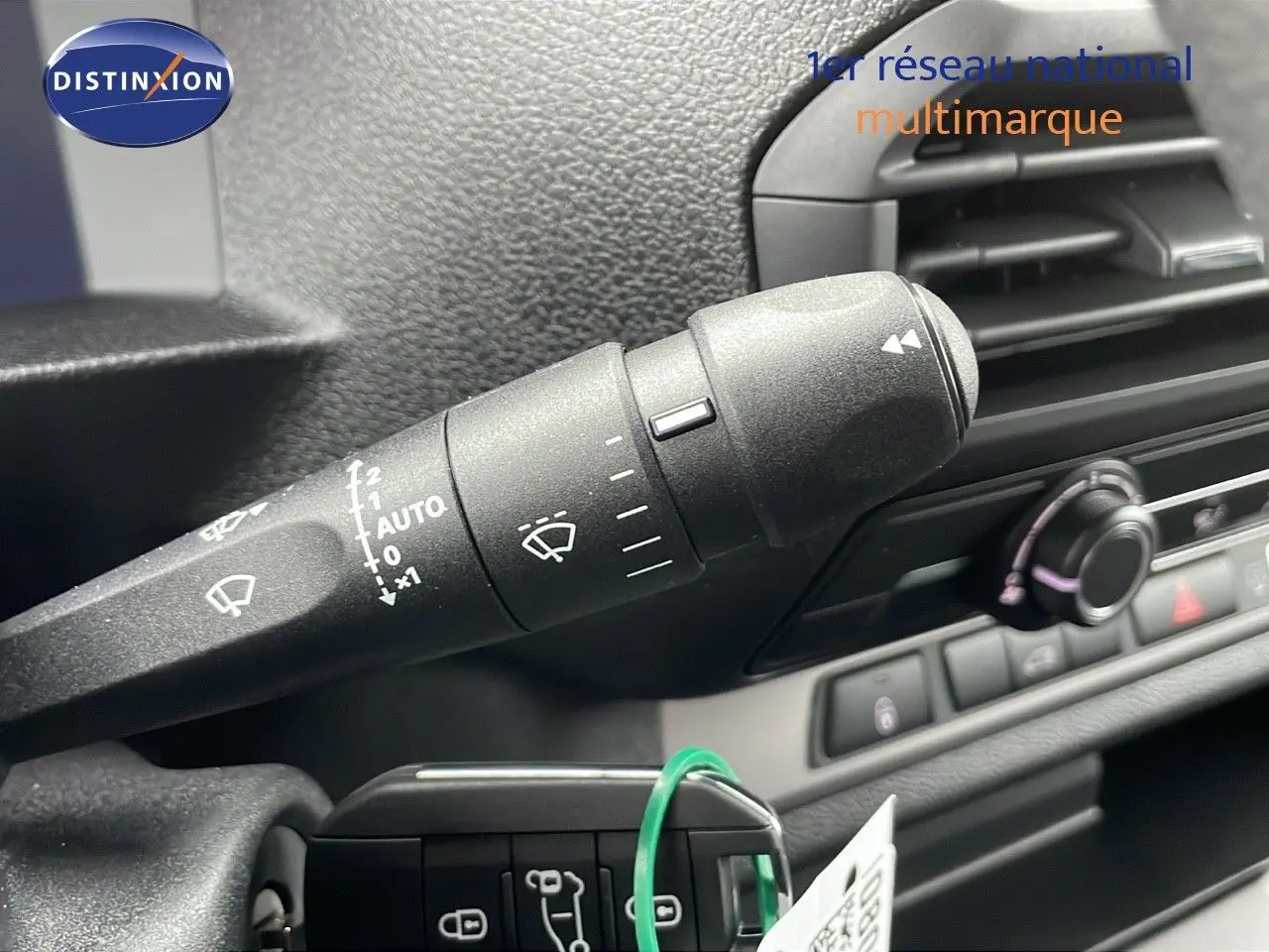 Gros plan sur la commande d'essuie-glace à gauche du volant du Peugeot Expert Fourgon blanc, intérieur noir.