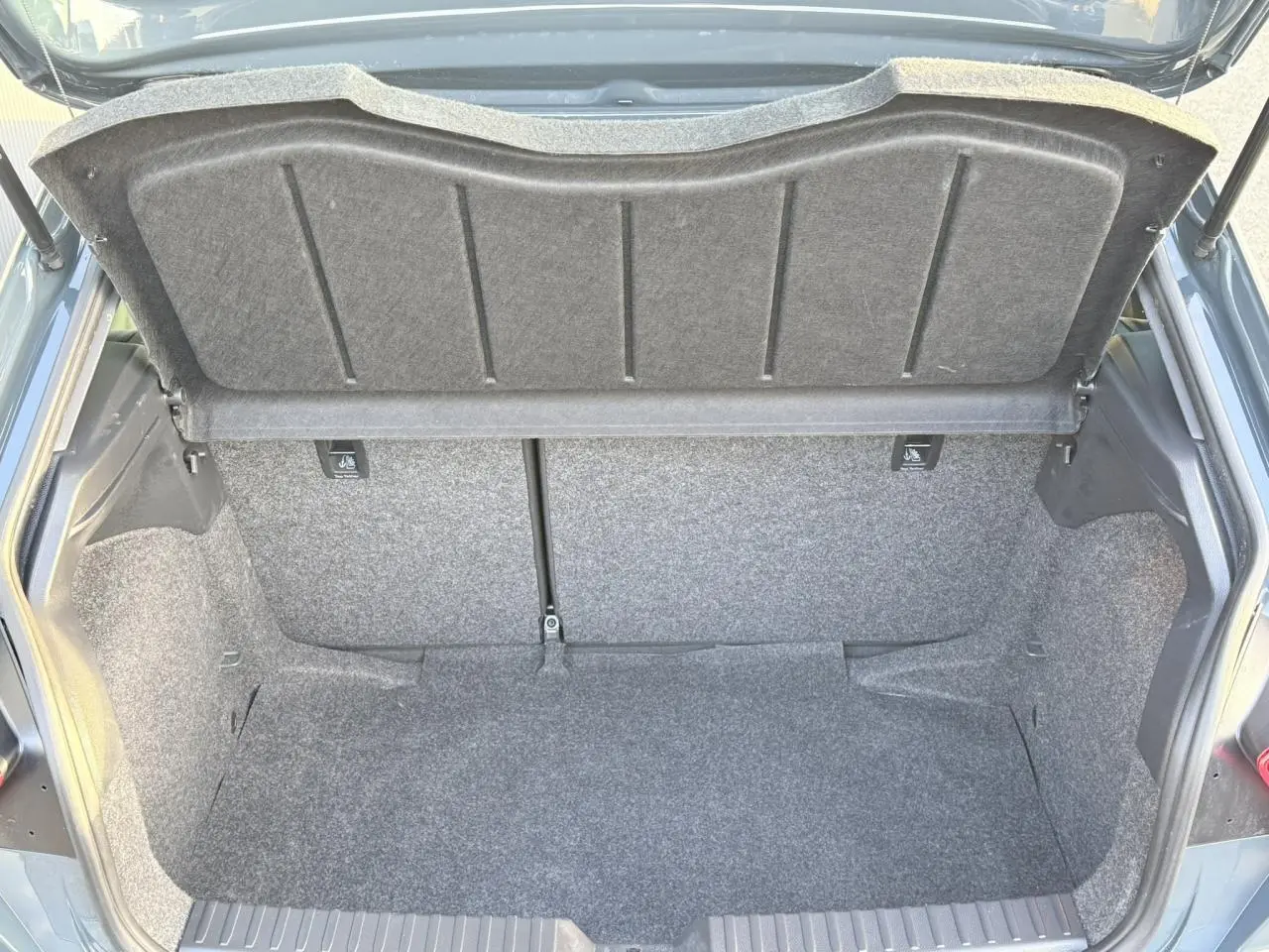 Coffre ouvert de la SEAT Ibiza TSI 115 Xcellence bleu Fjord, vue arrière montrant l'espace de chargement vide.