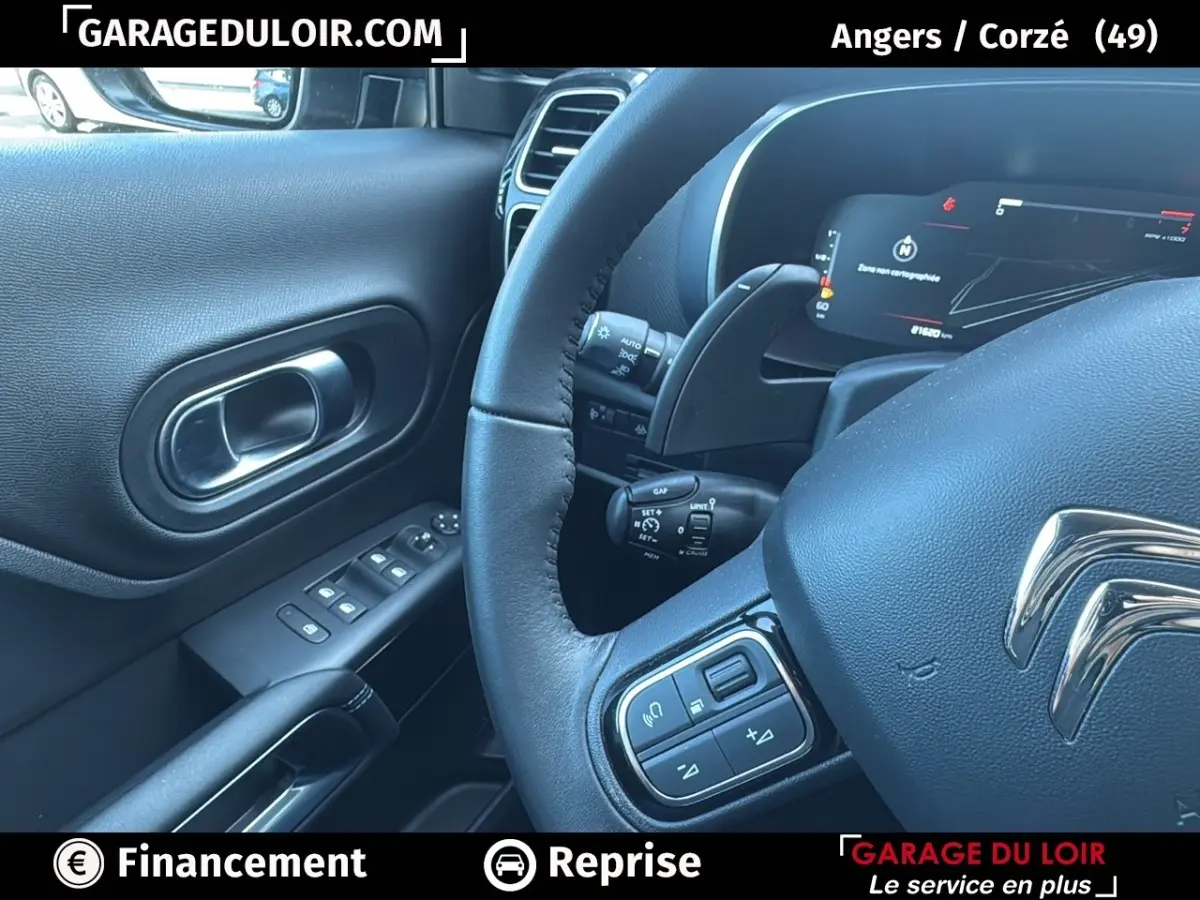 Intérieur noir du Citroën C5 Aircross 2025, vue sur le volant cuir et le tableau de bord numérique côté conducteur.