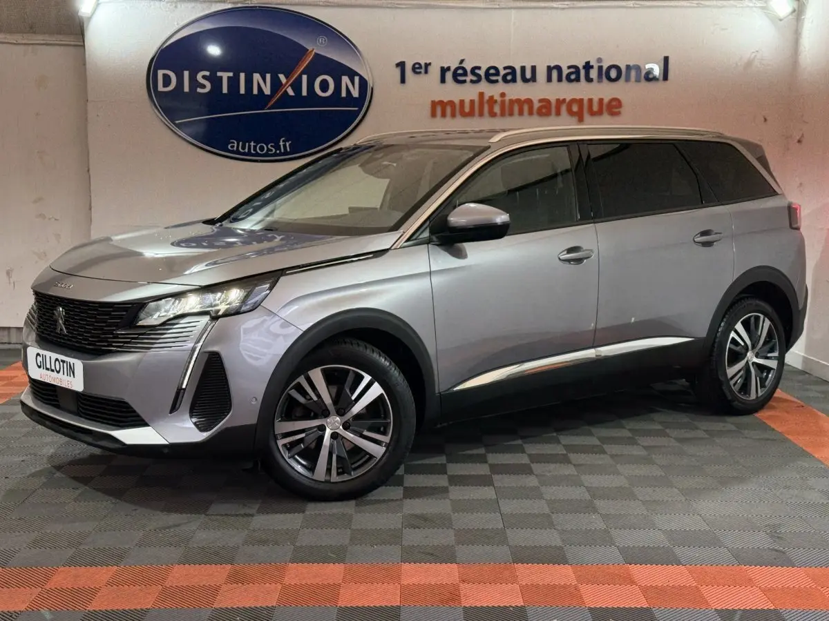 Peugeot 5008 gris clair vue de côté droit en intérieur, mettant en valeur ses phares LED et jantes alliage.
