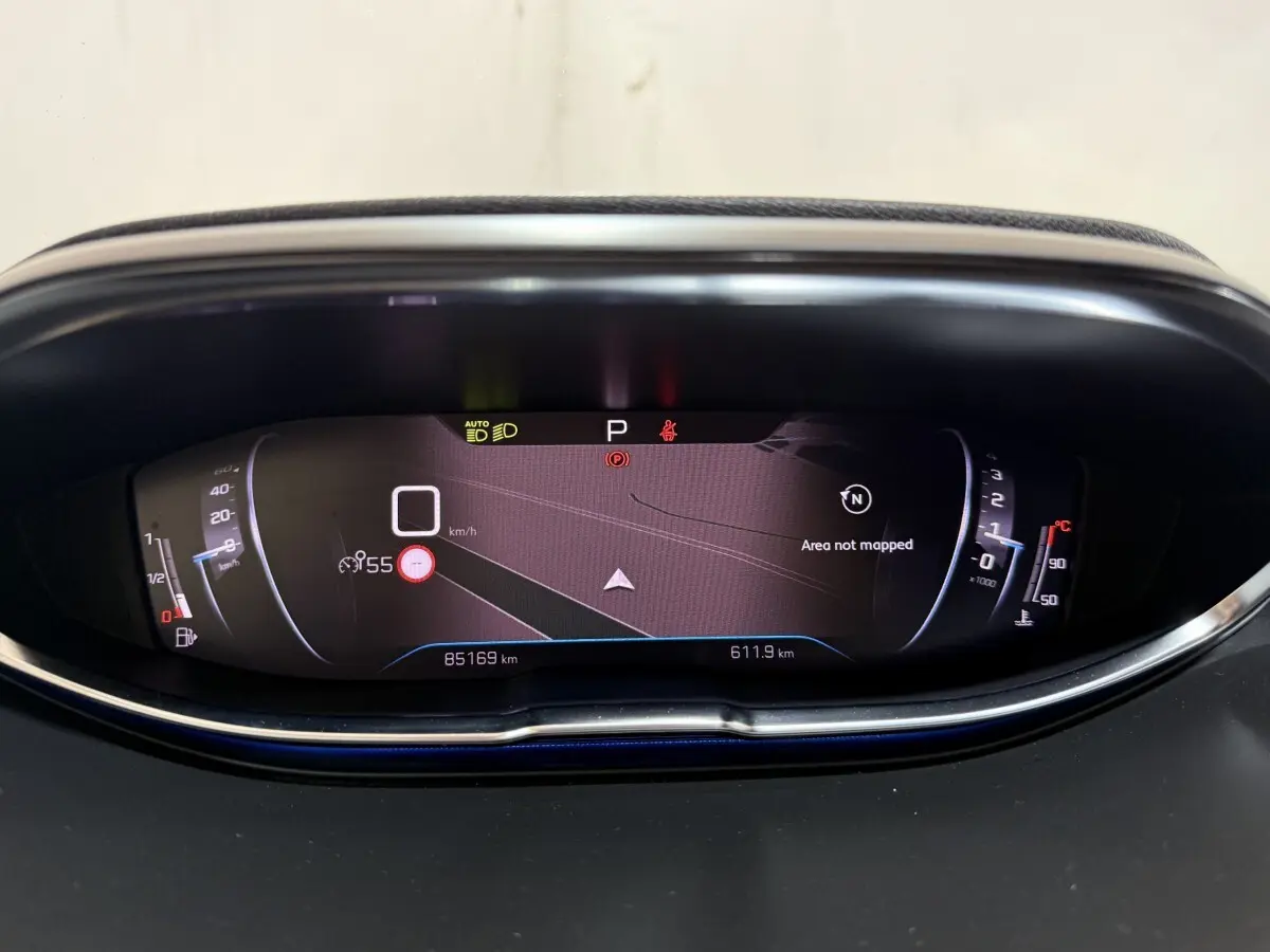 Affichage numérique du tableau de bord du Peugeot 5008 gris clair, montrant la navigation et compteurs à l'arrêt.