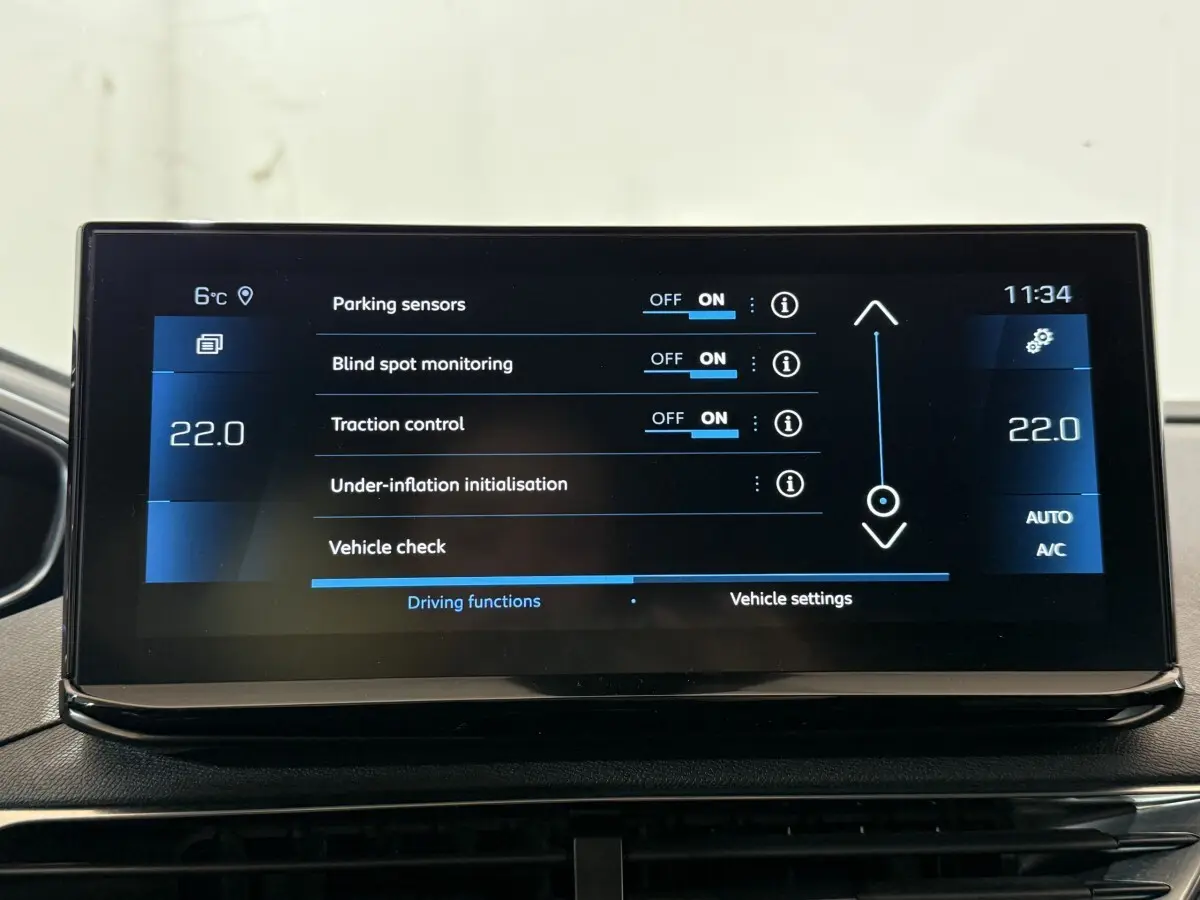 Écran tactile central du Peugeot 5008 gris clair affichant les réglages d’aide à la conduite et climatisation.