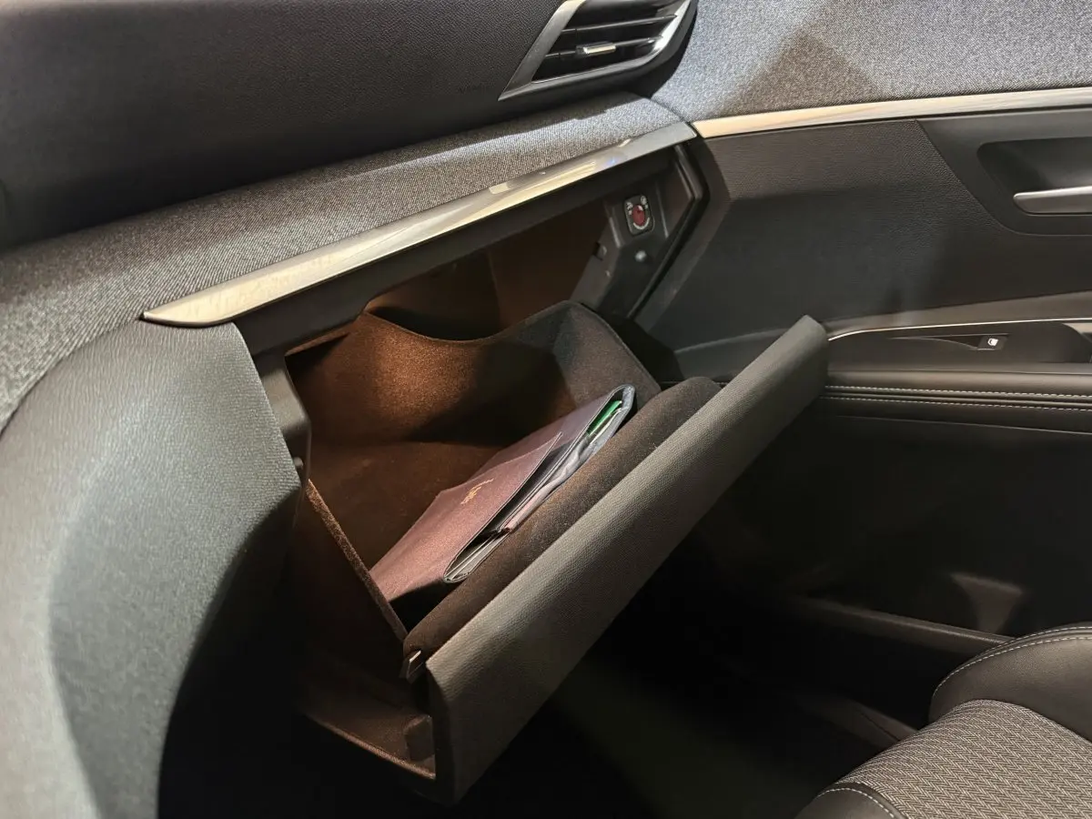 Vue intérieure côté passager du Peugeot 5008 2021, boîte à gants ouverte avec document à l'intérieur.