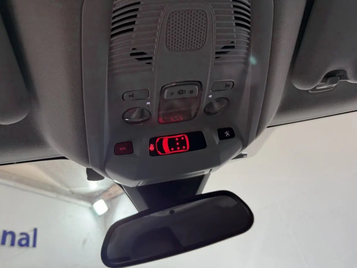 Vue intérieure du plafonnier avec commandes et affichage lumineux rouge dans un Peugeot 5008 gris clair de 2021.