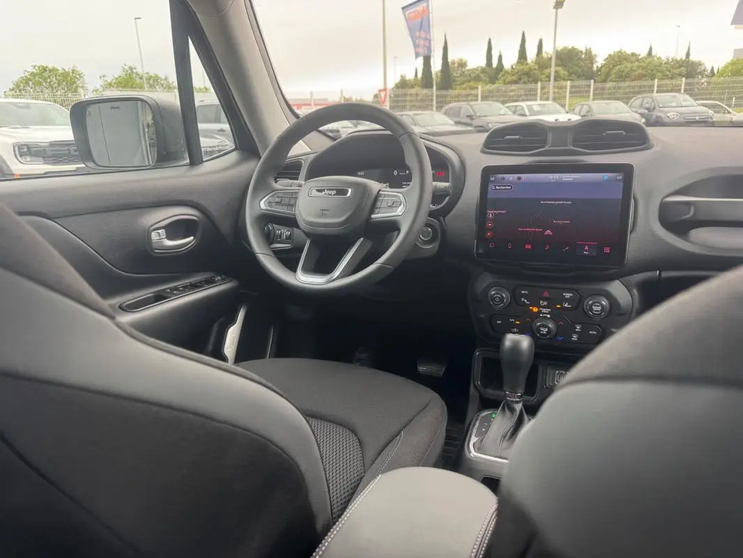 Intérieur du Jeep Renegade 2024 vu côté conducteur, volant multifonction et écran tactile central visibles.