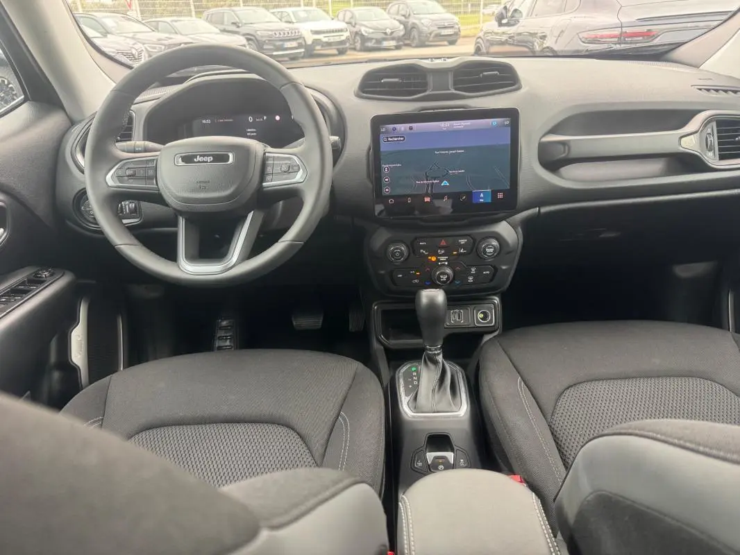 Vue intérieure avant du Jeep Renegade 2024 avec tableau de bord noir, écran tactile GPS et volant multifonction.