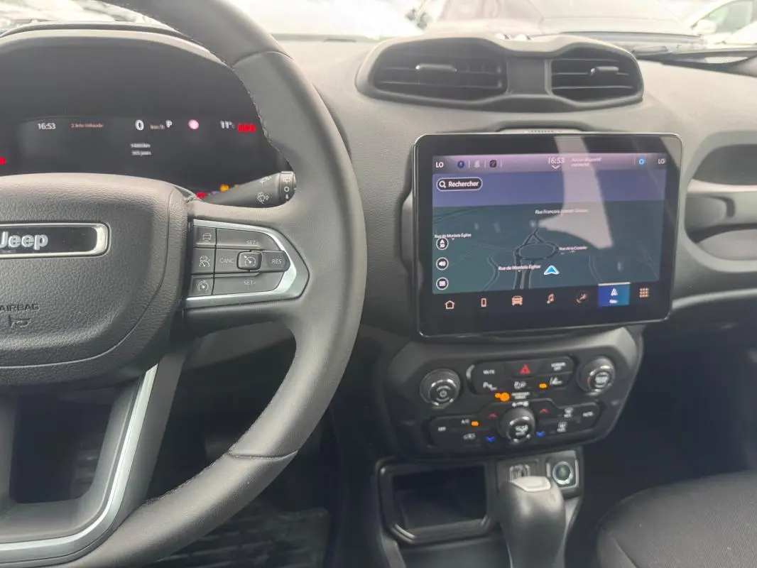 Vue intérieure centrée sur le volant Jeep et l’écran tactile GPS du tableau de bord du Renegade bleu 2024.