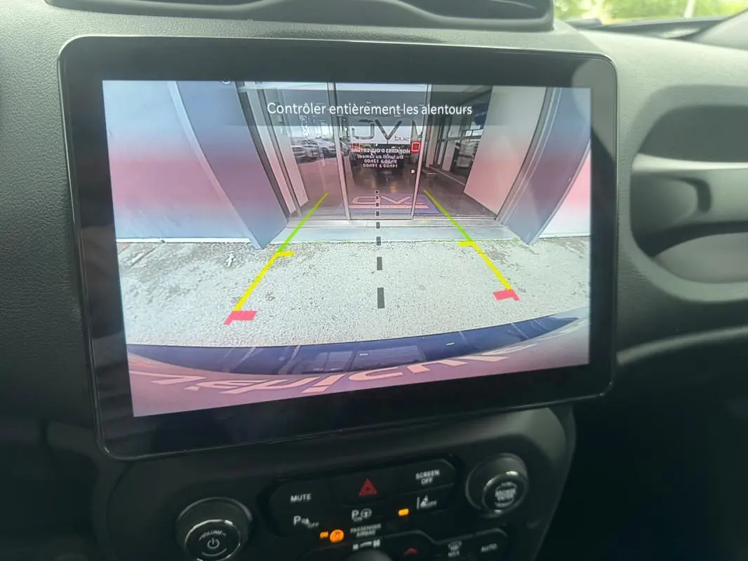 Écran tactile intérieur montrant la caméra de recul du Jeep Renegade bleu, avec guidage de stationnement visible.