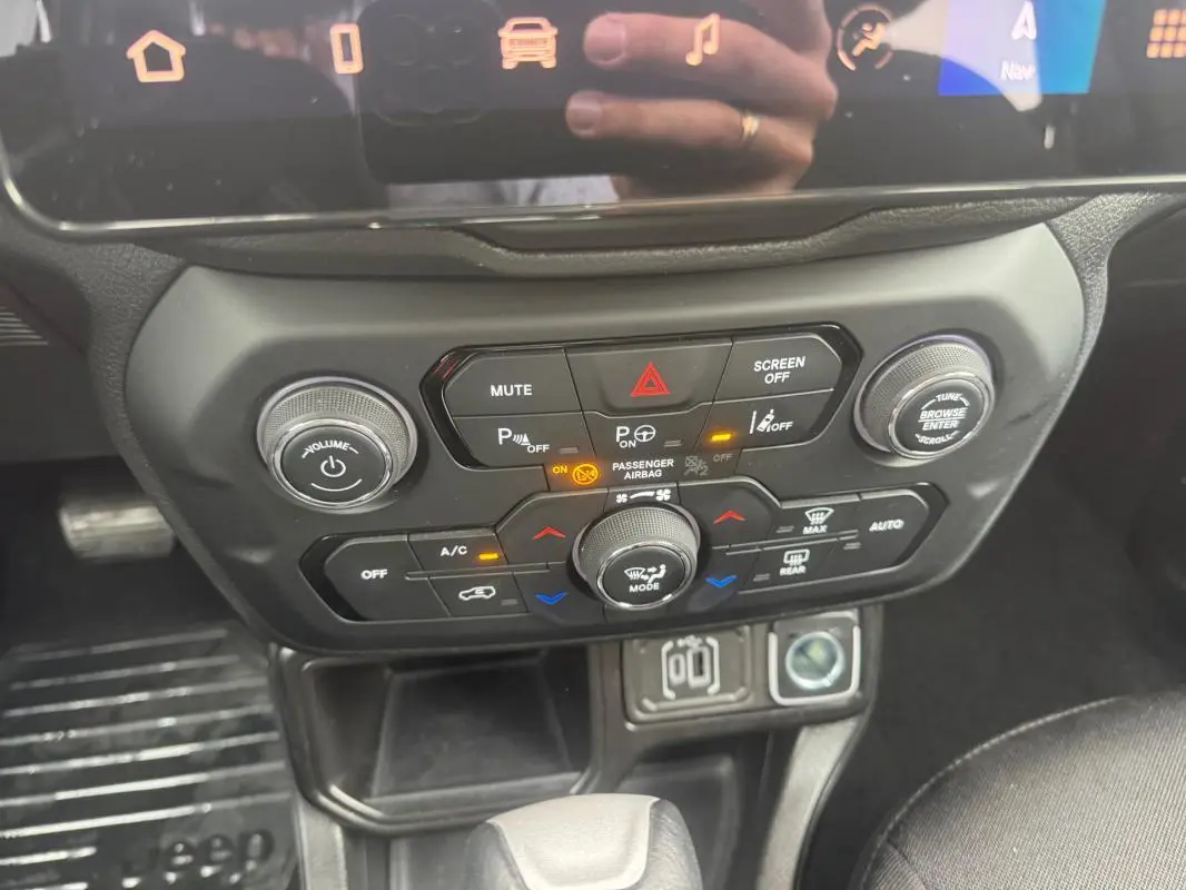 Vue rapprochée du tableau de bord et console centrale de la Jeep Renegade 2024, avec commandes climatisation et multimédia.