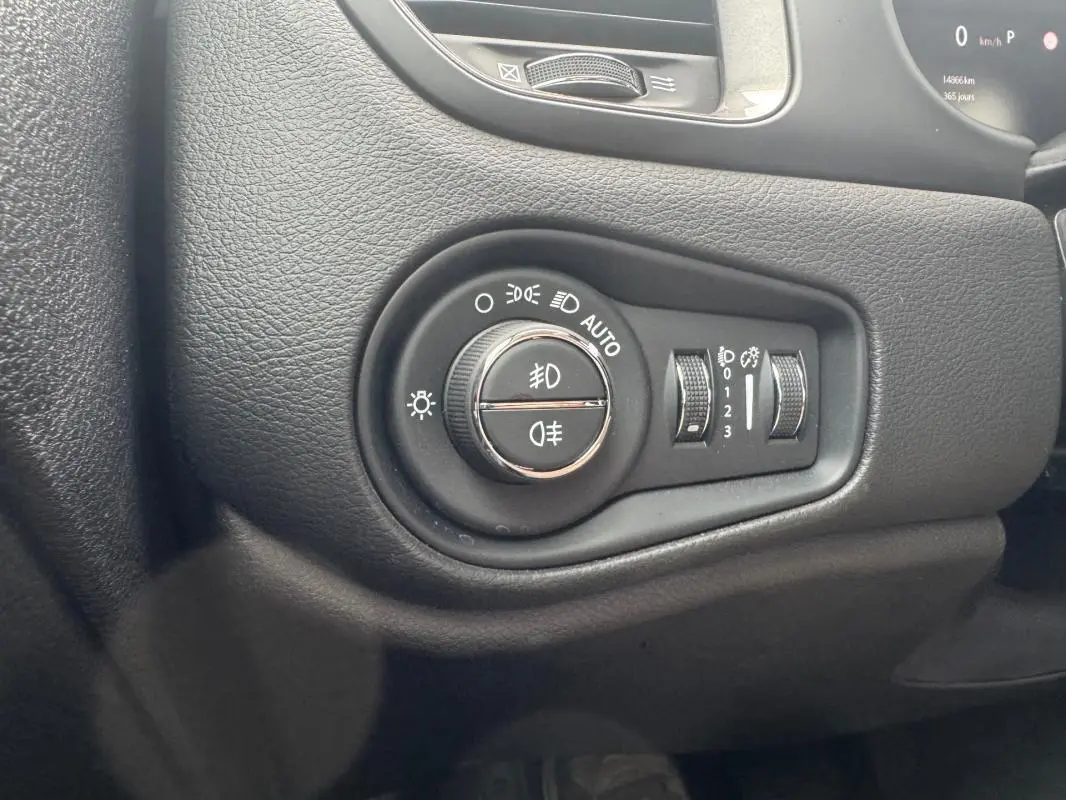 Gros plan sur le panneau de commande des phares du Jeep Renegade 2024, avec molette et réglages lumineux intégrés.