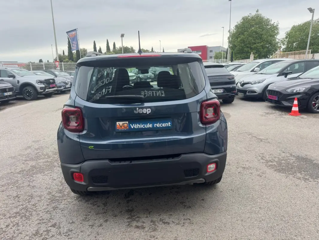 Vue arrière d’un Jeep Renegade bleu 2024 avec feux carrés caractéristiques et logo Jeep visible.