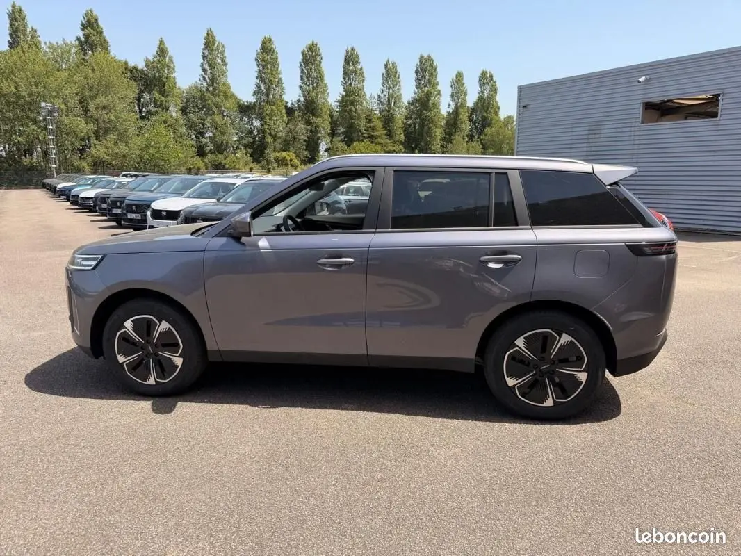 Vue de profil côté gauche du SUV JAECOO J5 gris Phantom, soulignant ses jantes noires au design futuriste.