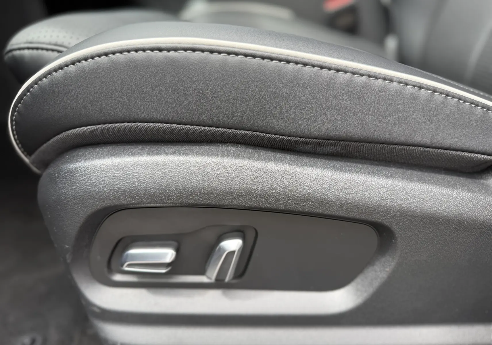 Gros plan sur les commandes de réglage électrique du siège en cuir noir du JAECOO J5 1.5 TGDI HEV 224CH BVA EXCLUSIVE.