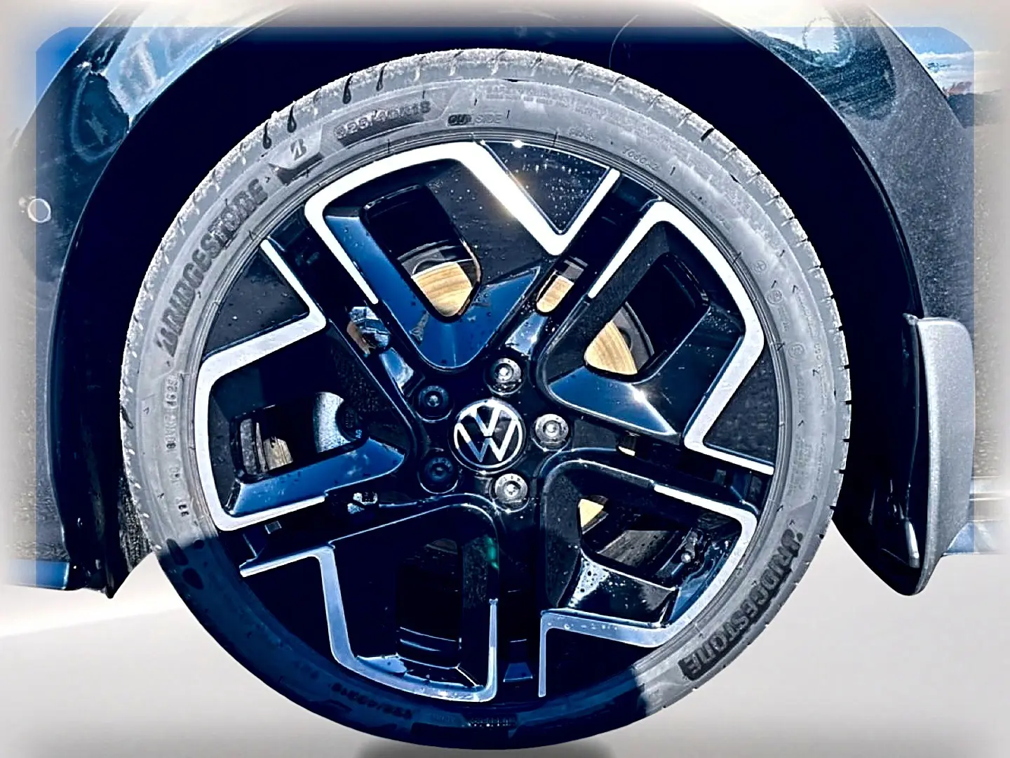 Gros plan sur la roue avant droite noire avec jante alliage noir et argentée de la Volkswagen Golf 1.5 etsi evo2 150 R-Line.