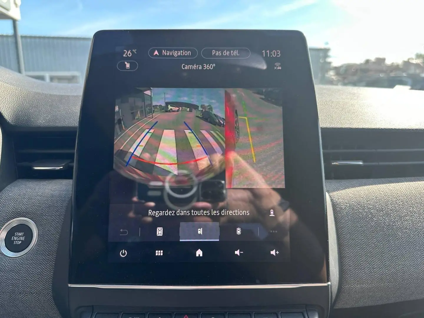 Écran tactile intérieur de Renault Clio 2025 montrant la caméra de recul 360°, avec tableau de bord gris et bouton Start/Stop.