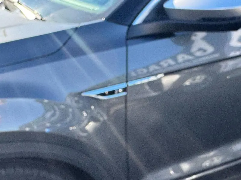 Détail du côté gauche bleu foncé du Volkswagen T-Roc 2019 avec prise d'air chromée près de l'aile avant.