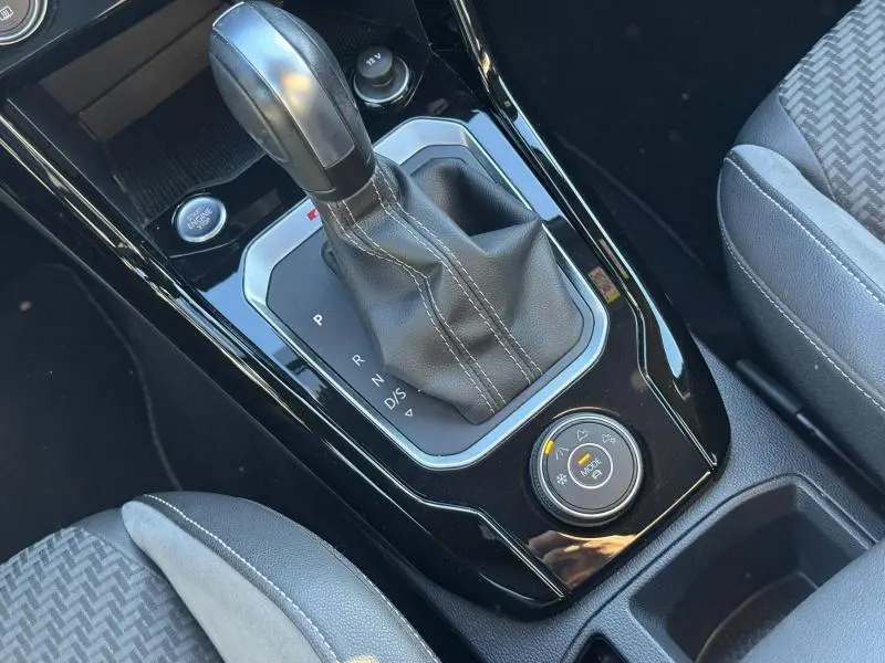 Gros plan sur la console centrale noire brillante du Volkswagen T-Roc 2019 avec levier de vitesse automatique et sélecteur de mode de conduite.