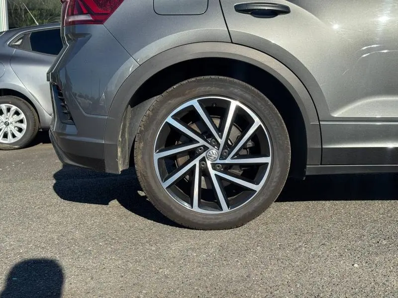 Gros plan sur la roue arrière droite gris métallisé du Volkswagen T-Roc 2.0 TSI 300ch R avec jante alu bicolore.