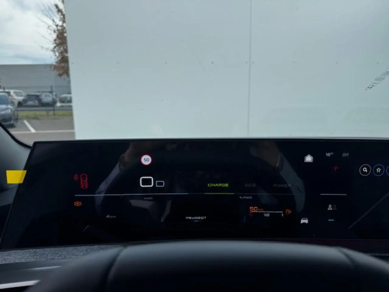 Tableau de bord numérique panoramique du Peugeot 5008 bleu Ingaro, vue depuis le siège conducteur.