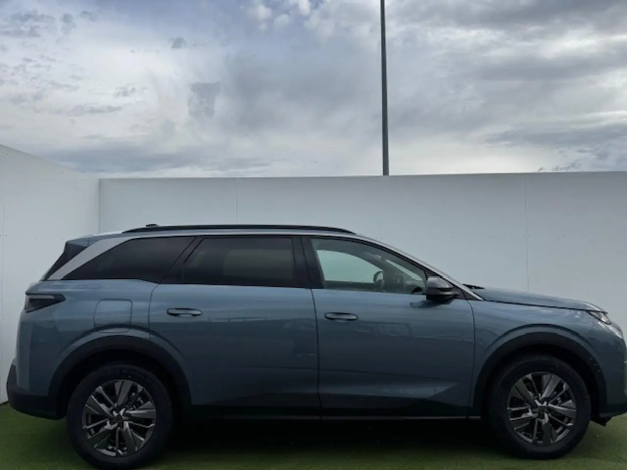 Profil droit du Peugeot 5008 bleu Ingaro métallisé avec toit noir et jantes alliage 18 pouces Maya