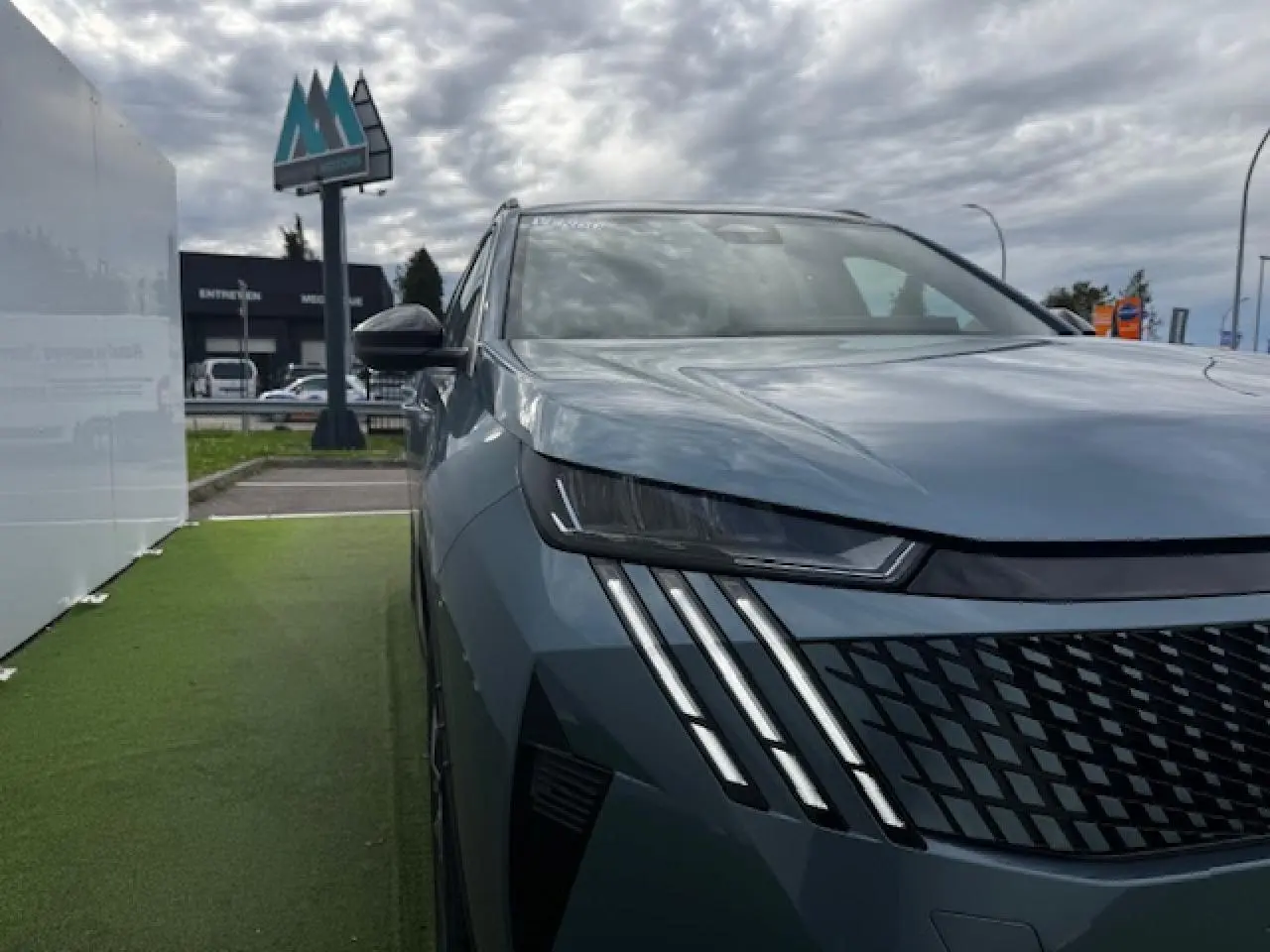Vue 3/4 avant gauche du Peugeot 5008 bleu Ingaro avec phares LED et calandre noire texturée.
