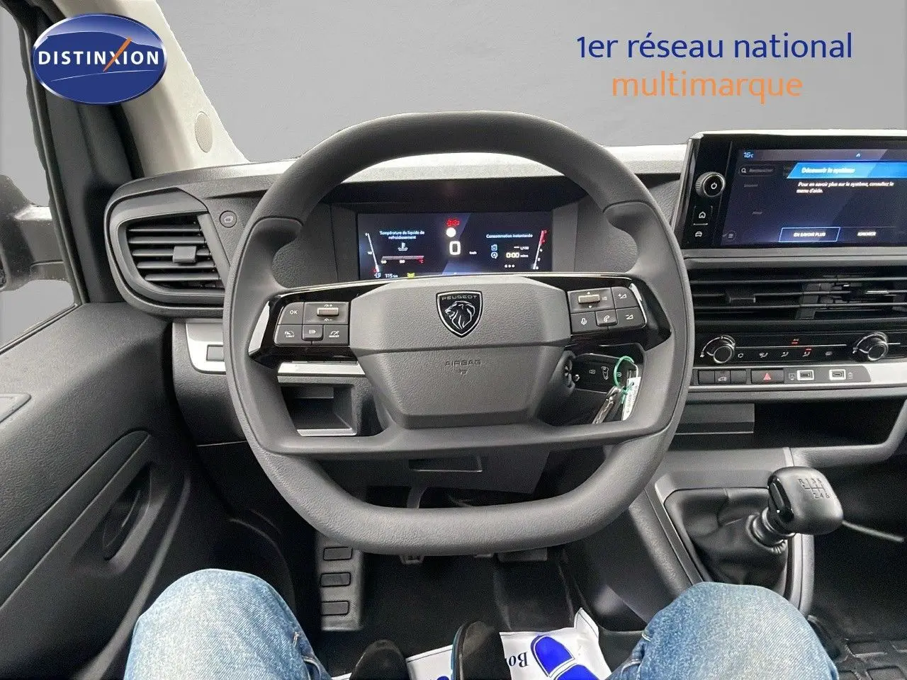 Vue intérieure centrée sur le volant et le tableau de bord du Peugeot Expert Fourgon blanc avec boîte manuelle.