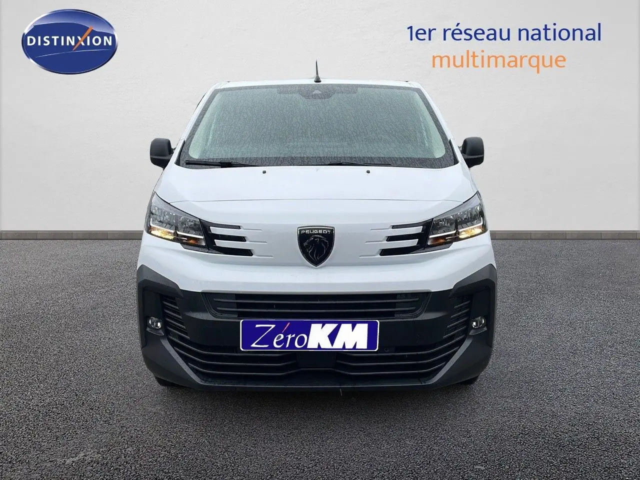 Vue frontale d'un Peugeot Expert Fourgon blanc 2025 avec calandre noire et phares allumés sur fond neutre.